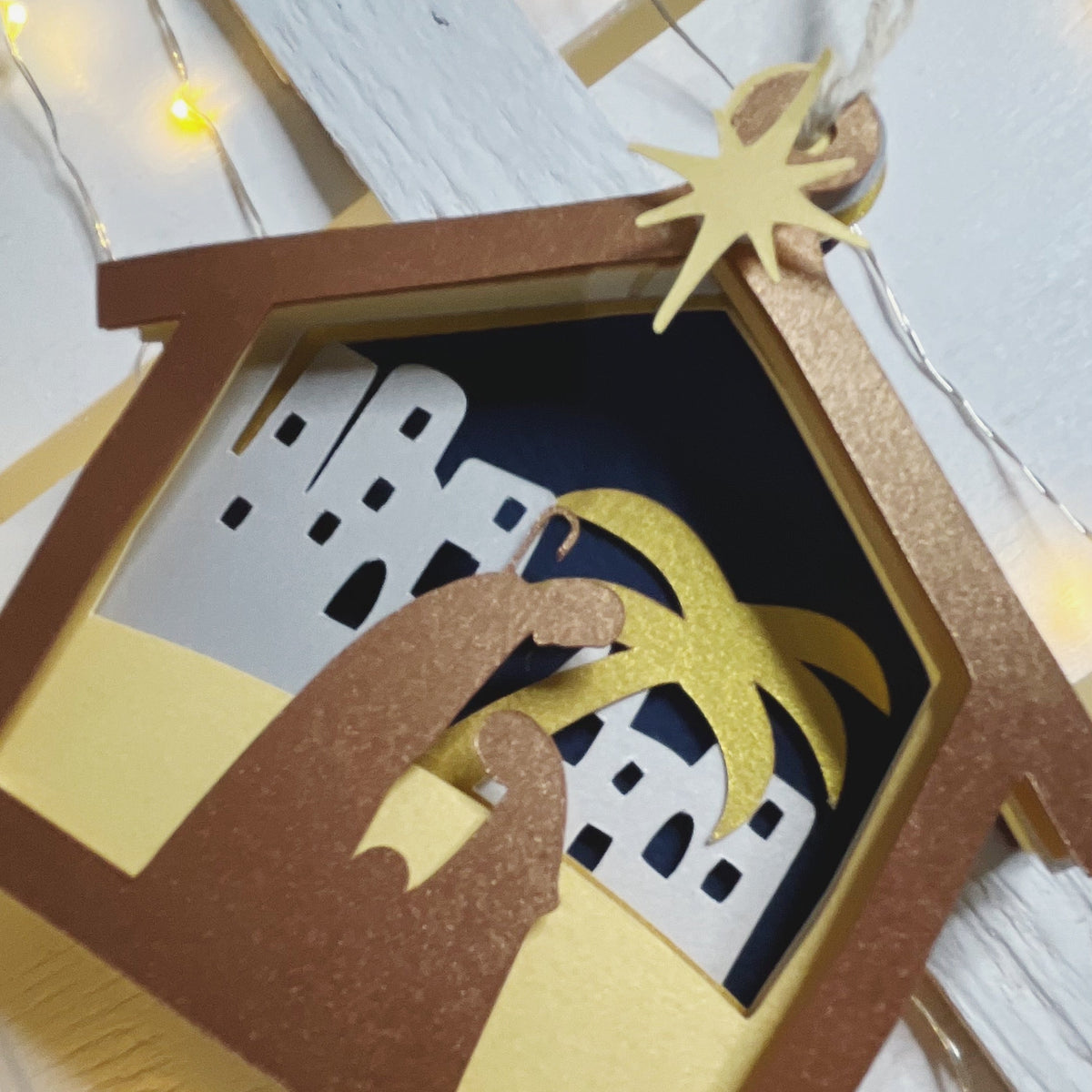 Presepe natalizio in carta esposto su una mensola, idea regalo